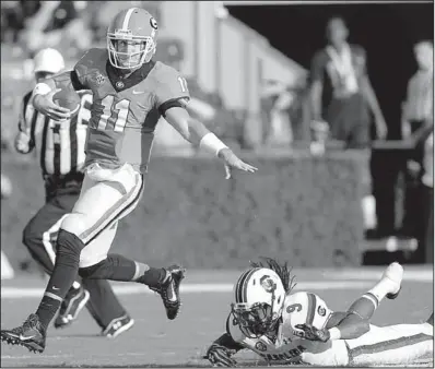  ?? AP/JOHN BAZEMORE ?? Georgia quarterbac­k Aaron Murray (left) runs past South Carolina linebacker Sharrod Golightly on Saturday in Athens, Ga.