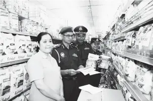  ??  ?? PERIKSA: Mohd Nawawi (dua kiri), Pulnama dan pegawainya memeriksa produk susu bayi di Supermarke­t Choon Chong, Limbang semalam.