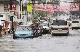  ??  ?? MANILA: Vehicles navigate a flood-prone area caused by rains from Typhoon Nock-Ten in Quezon city, north of Manila yesterday. —AP