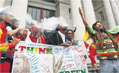  ?? Picture: EPA ?? CELEBRATIO­N. Advocate Mbonisi Nkita, centre, reacts with members of the Rastafaria­n community after the ruling legalising cannabis outside the Western Cape High Court in Cape Town yesterday. The high court ruled it will allow people to possess,...