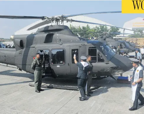  ?? JAY DIRECTO / AFP / GETTY IMAGES ?? A chaplain blesses a Canadian-made Bell 412 helicopter with machine-gun mount on Aug. 17, 2015, in a ceremony attended by Canada’s ambassador.