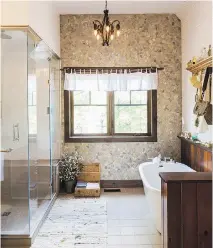  ??  ?? Modern and antique are combined in the en suite, which includes details like the wicker fish basket above the bathtub that holds hand towels.