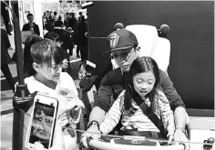  ??  ?? Many visitors have their children try their hands at the AR cabins – UD Trucks’ key attraction during the Tokyo Motor Show 2017.