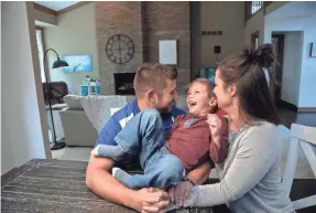  ?? MANDI WRIGHT/USA TODAY NETWORK ?? Andrew and Sarah Smith play with son Jonathan in their new home in Rochester Hills. They sold their old home for cash.