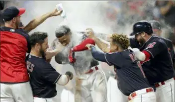  ?? TONY DEJAK — THE ASSOCIATED PRESS ?? Cleveland’s Francisco Lindor, center, is welcomed by teammates after he hit a walk-off three-run home run against the Twins Wednesday in Cleveland. The Indians won 5-2.