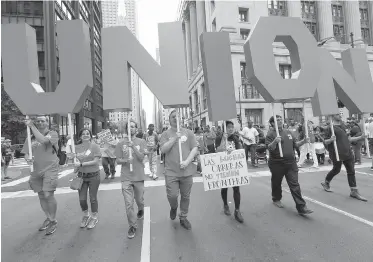  ??  ?? Union supporters march on Labour Day 2017 in downtown Chicago to protest low wages. Letter-writers suggest that instead of reducing public-sector wages and benefits, the private sector’s pay should be increased.