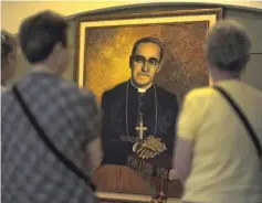  ??  ?? File photo shows tourists watching a portrait of Romero near his tomb at the National Cathedral in San Salvador. — AFP photo