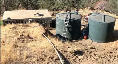  ?? PHOTO FOR THE RECORDER BY BRENT GILL ?? The old leaky cistern on the left, with the two new 5,000 gallon tanks on the right. The new tank on the left has a hole drilled in the top for the pipe which brings water from the spring.