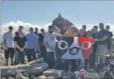  ??  ?? The triumphant team on the summit standing in front of Bert’s peace cairn with the Black Country flag.