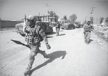  ?? Ahmad al-Rubaye AFP/Getty Images ?? IRAQI forces gather at Mosul’s airport during their offensive to retake the western side of the city from Islamic State militants. Recapturin­g Mosul has been a top priority of the Iraqi government.