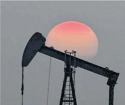  ?? CHRISTIAN HARTMANN/REUTERS ?? The sun sets behind an oil pump outside Saint-Fiacre, near Paris, France, earlier this year.