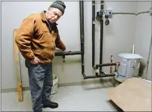  ?? DANA JENSEN/THE DAY ?? Norwich Director of Inspection­s James Troeger, who will be retiring soon, turns to tell Richard Haack, job supervisor for Pelletier Builders, who is standing in the hall, that he discovered a loose ground wire for the water meter in a utility room Wednesday, Dec. 18, during his inspection. The building will be the new home of ROOT Center for Advanced Recovery in Norwich.