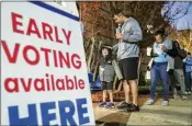  ?? JOHN SPINK/JOHN.SPINK@AJC.COM ?? Josh Weeks waits in line with son Noah, 4, as early voters hit the polls Nov. 4 at the Joan P. Garner Library in Atlanta.