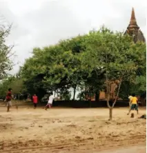  ??  ?? WHILE AWAY THE TIME. Kids play football, Myanmar’s favorite pastime, at an empty lot near a shrine.