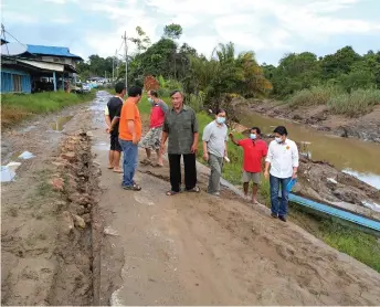  ?? ?? Dennis (right) checks the riverbank with Long Wat residents.