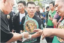  ?? — AFP photo ?? Undefeated Thai boxer Wanheng Menayothin wears his WBC title belt after defeating Panamanian challenger Leroy Estrada to win his 50th straight victory in Nakhon Ratchasima. • Another photo Page 23