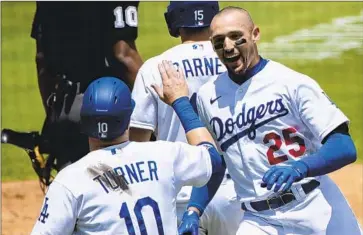  ?? Photograph­s by Gina Ferazzi Los Angeles Times ?? TRAYCE THOMPSON and Justin Turner exchange a high-five after both scored on a double to right by Hanser Alberto during a six-run first inning in a 7-1 victory to avoid a series sweep against the lowly Nationals.