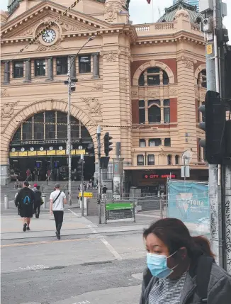  ??  ?? EMPTY STREETS: Australian­s are being warned the changes to daily as a virtually empty Flinders Street station precinct suggests. life are a long-haul measure