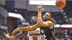  ?? Jessica Hill / Associated Press ?? UConn’s Sidney Wilson (15) loses the ball as he tangles with Central Florida’s Darin Green Jr. in the first half on Wednesday.