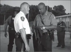  ?? The Associated Press ?? DIFFERENT SCENE: St. Louis County Police Chief Jon Belmar, left, and Highway Patrol Capt. Ronald
Johnson confer, Monday in Ferguson, Mo.