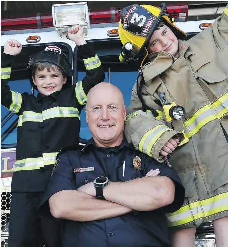  ?? DAN JANISSE ?? Lakeshore fire Capt. Francois Brule, centre, hams it up with two young firefighti­ng fans, Brody Prestyko, 7. left, and Brenden Prestyko, 9, last week at the Belle River firehall. On Nov. 11, Brule will run in a 100-mile race to raise money for two...