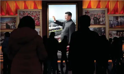  ?? Celis/AFP/Getty Images ?? Visitors walk in front of a picture of Xi Jinping at the Museum of the Chinese Communist party in Beijing on Thursday. Photograph: Noel