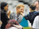  ?? Dominic Lipinski ?? The Associated Press A boy strokes Prince Harry’s beard, as Meghan, the Duchess of Sussex, smiles Wednesday at Croke Park in Dublin.