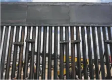  ?? Guillermo Arias / AFP / Getty Images ?? U.S. workers are seen through the border fence in Tijuana.