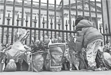  ?? JUSTIN TALLIS/AFP VIA GETTY IMAGES ?? Word of Prince Philip's death Friday brought crowds of subjects to Buckingham Palace in London. Queen Elizabeth II'S husband, who recently spent more than a month in hospital and underwent a heart procedure, was 99.