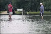  ?? GERALD HERBERT — THE ASSOCIATED PRESS ?? Danny Gonzales, right, stands in front of his house with his neighbor Bob Neal, after Tropical Depression Claudette flooded Slidell, Louisiana, on Saturday.