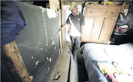  ?? / PHOTOS: THULANI MBELE ?? Mbuyiselo Mthimkulu inside his bedroom where a headstone of a grave is seen underneath his carpet in Hlala Kwabafiley­o, Tshepiso, near Sharpevill­e. Mthimkulu says he didn’t know there was a grave in his house when he moved in.