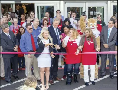  ?? Photo by Eric Melander ?? Miss Hobble Creek 2016 Kte Keetch, surrounded by excited city officials, Deseret Industries employees and residents, prepares to cut the ribbon to officially open the new Springvill­e Deseret Industries on Oct. 27.