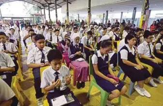  ?? PIC BY MOHD RADZI BUJANG ?? SK Green Road pupils praying before taking the Bahasa Melayu paper in Kuching yesterday.