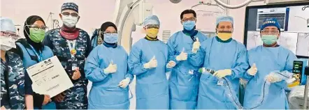  ?? — IJN ?? Dr Amin (second from right) holding up the IVL equipment, with the team of cardiologi­sts, nurses and one technician who helped with the procedure.