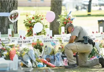  ?? WALLY SKALIJ/LOS ANGELES TIMES ?? An officer places flowers Thursday outside Robb Elementary School in Uvalde, Texas.