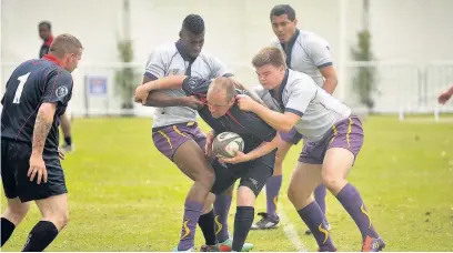  ??  ?? Tackles were flying in on the rugby field as members of 27 Regiment (whites tops) got to grips with their 4th Regiment opponents.