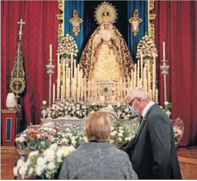  ??  ?? Unos devotos llevan flores a la Virgen de los Dolores en su iglesia de las Colonias.