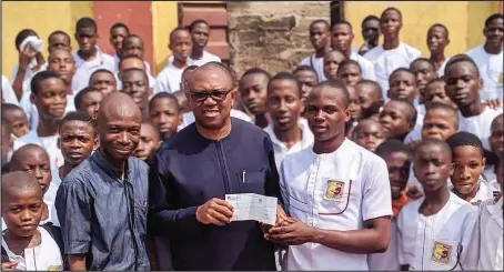  ??  ?? Former Governor of Anambra State, Peter Obi with students of Peterson Memorial Grammar School, during his previous visit when he donated N1 million to support the rebuilding of their burnt hostel