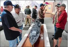  ?? SEAN D. ELLIOT/THE DAY ?? Former crew members of the Coast Guard cutter Owasco (WHEC 39) discuss a model of the 255-foot cutter, based on the 1944 commission­ing plan, on Monday at the Coast Guard Museum at the Coast Guard Academy in New London.