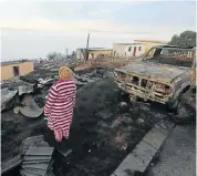  ??  ?? CHARRED: A resident of White Location in Knysna surveys the burnt-out houses left after the runaway fire