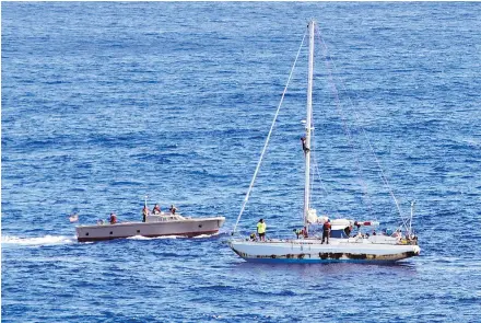  ?? PHOTOS: MASS COMMUNICAT­ION SPECIALIST 3RD CLASS JONATHAN CLAY / U.S. NAVY VIA THE ASSOCIATED PRESS ?? Sailors from USS Ashland approach a sailboat with two Honolulu women and their dogs aboard as they are rescued after being lost at sea. The U.S. Navy rescued the women last Wednesday after a Taiwanese fishing vessel spotted them about 1,450 km...