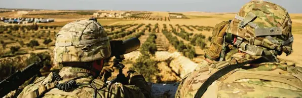  ?? Foto: Susannah George, dpa ?? Zwei US-Soldaten blicken von Syrien aus auf die türkische Grenze. Die Kurden fürchten eine türkische Offensive, wenn die amerikanis­chen Truppen die Region tatsächlic­h verlassen haben.