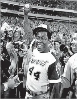  ?? Bob Daugherty Associated Press ?? HOME RUN KING A triumphant Aaron holds the ball he hit for the 715th home run of his career to break Babe Ruth’s all-time record, which had stood for nearly 40 years.