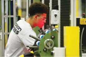  ??  ?? An employee works with a machine inside the plant. The company expects to make 1 million tires this year.