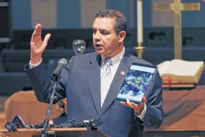  ?? Jerry Lara / Staff photograph­er ?? U.S. Rep. Henry Cuellar shows a photograph Monday of a migrant child he met in Laredo. Cuellar was joined by local and city officials along with nonprofit representa­tives in announcing nearly $30 million in reimbursem­ent for migrant aid.