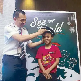  ??  ?? Capt. Darren Acorda awards pilot badge to World Vision beneficiar­y Leonardo Zonio of Kalibo, Aklan.