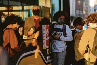  ?? Armando Franca / Associated Press ?? Children wearing masks board a bus in Lisbon, Portugal. Even though the nation has inoculated 86% of the population, its prime minister is bringing back some tight pandemic restrictio­ns.