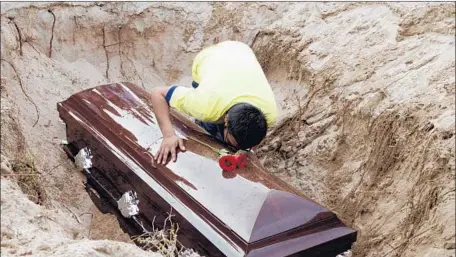  ?? Francisco Robles AFP/Getty Images ?? A SON of Carlos Dominguez mourns over the coffin of the 77-year-old Mexican opinion columnist who was stabbed 21 times by three men.