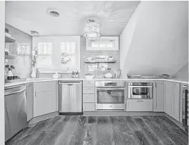  ?? Creators Syndicate photo ?? This kitchen’s designer worked diligently with what was available to capture new space and deliver a functional, modern kitchen. Symmetry has been neglected in favor of function.