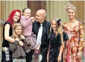  ??  ?? Honour: Midge Ure collects his OBE in 2005, with his daughters and wife Sheridan, right; at the recording of the Band Aid single with Bob Geldof, far right, in 1984